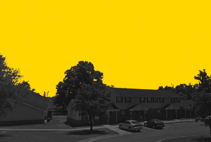 Brantwood Apartments in Centreville, Alabama, a row of townhome-style apartments, in a yellow and black duotone treatment.