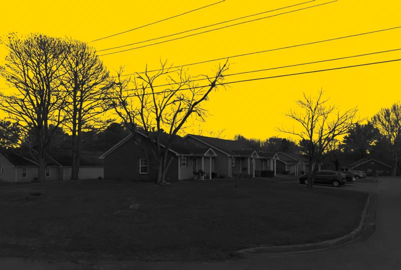 Countrywood Apartments in Centreville, Alabama, a row of single-story townhomes, in a yellow and black duotone treatment.