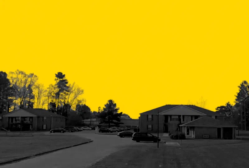 Hunter Pointe Apartments in Centreville, Alabama, a two-story garden-style apartment community, in a yellow and black duotone treatment.