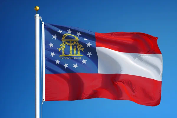 State flag of Georgia flying against a blue sky.