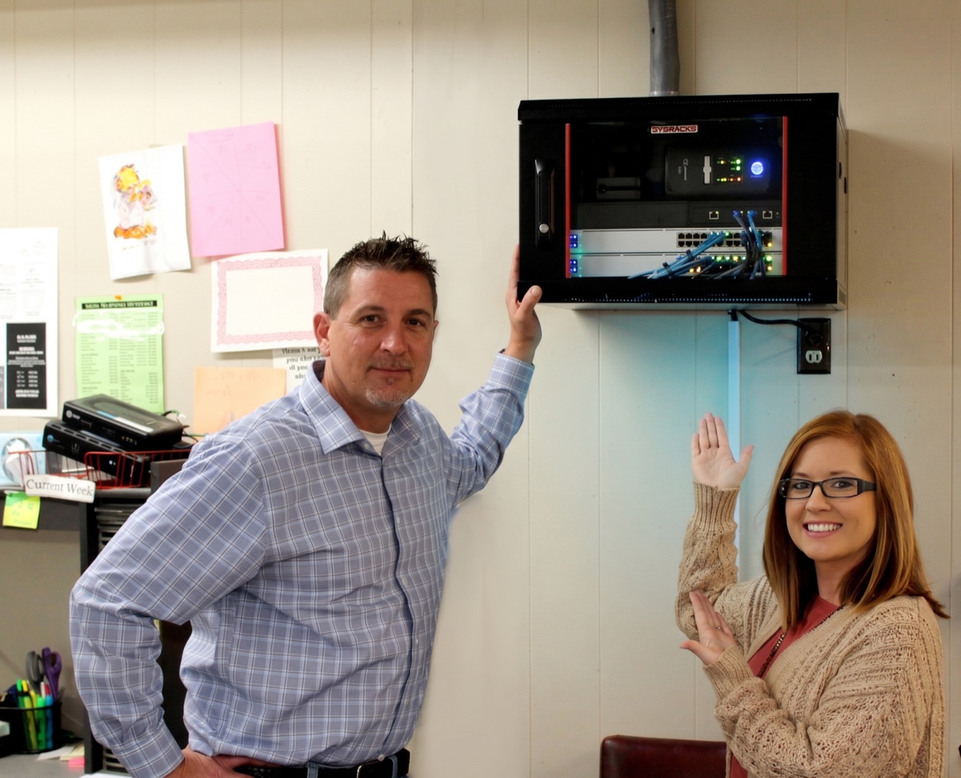 An Alabama Lightwave technician chatting with a customer next to her newly installed network cabinet.